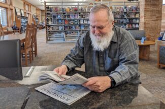 man reading newspaper at library