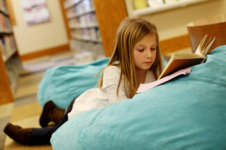 gril reading a book on a beanbag